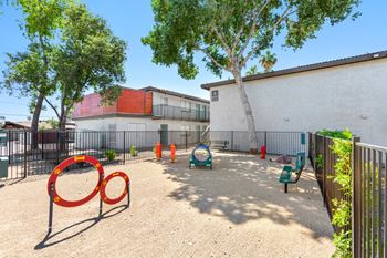 A playground with a red swing set and a green slide.
